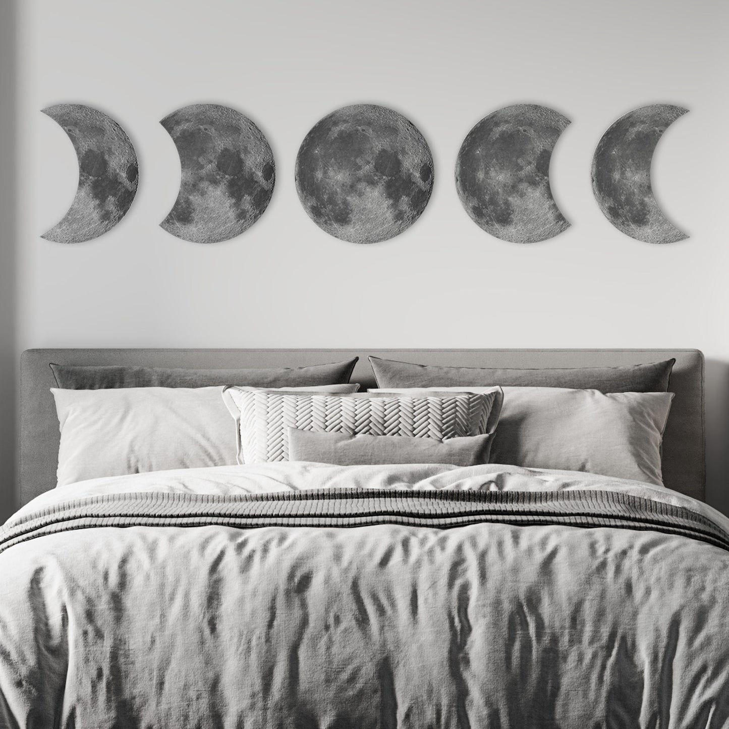 Moon phases wall decor displayed above bed in modern bedroom, celestial wall art focal point