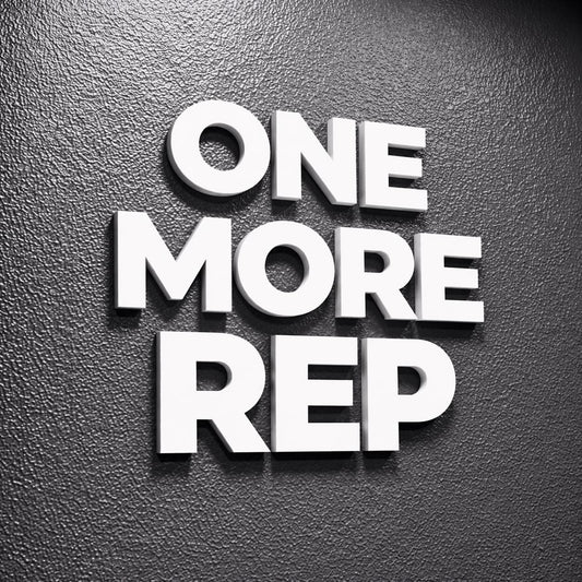 White 3D text on a textured dark gray background reads "ONE MORE REP." The letters are bold and stand out, creating a motivational message. The image is a close-up, emphasizing the text's prominence.